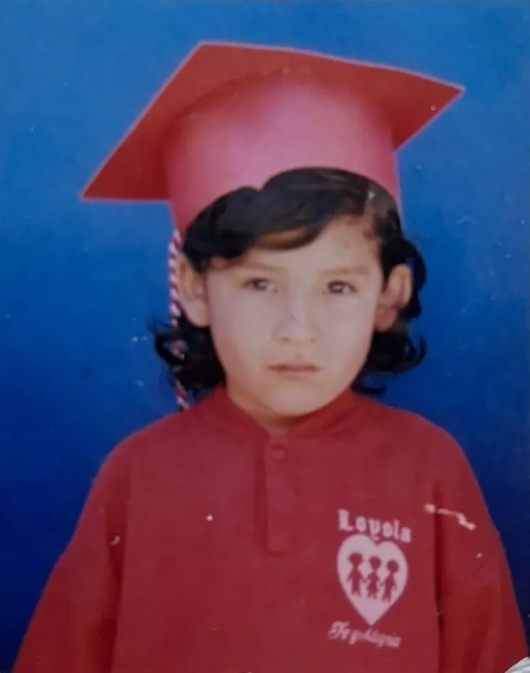 Anette de niña con su primer birrete en el kínder